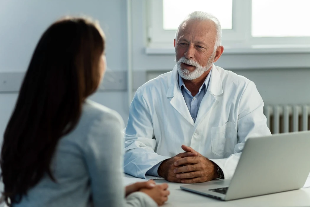 Senior doctor talking to female patient during medical consultations at doctor's office