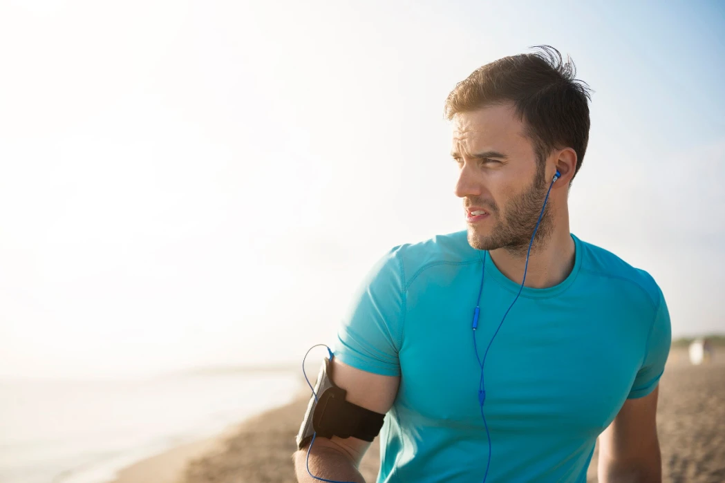Close up on young fit person jogging by the sea