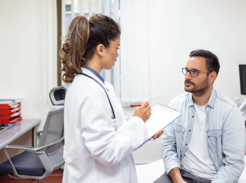 Serious man consulting with young female physician doctor at checkup meeting in hospital Skilled general practitioner giving healthcare medical advices to patient